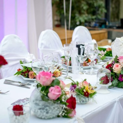 Beautifully decorated wedding table setting with floral arrangements and wine glasses, creating an elegant atmosphere.